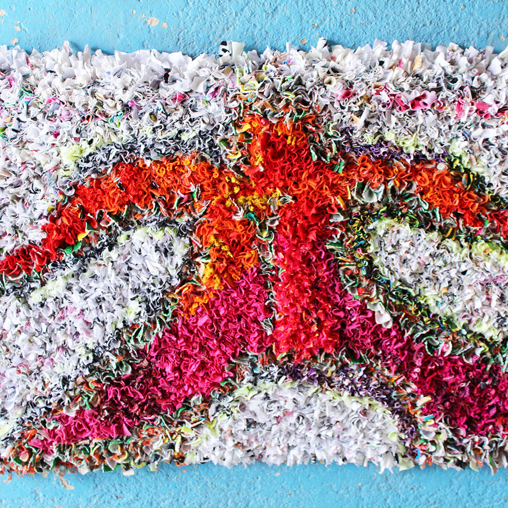 Ragged Life colourful proggy mat with outline of person in red and pink fabric