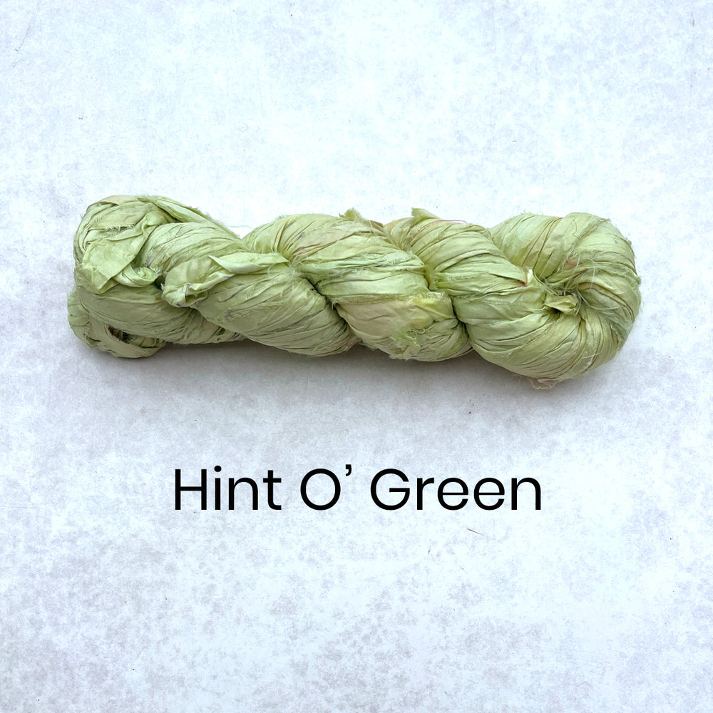 Light green 100g skein of recycled sari silk ribbon for textile crafts and rug making. 