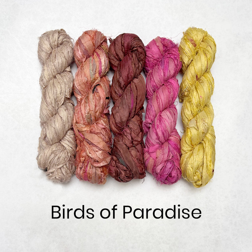 Light tan, coral, brown, pink and yellow skeins of sari silk ribbon for rug making and textile crafts