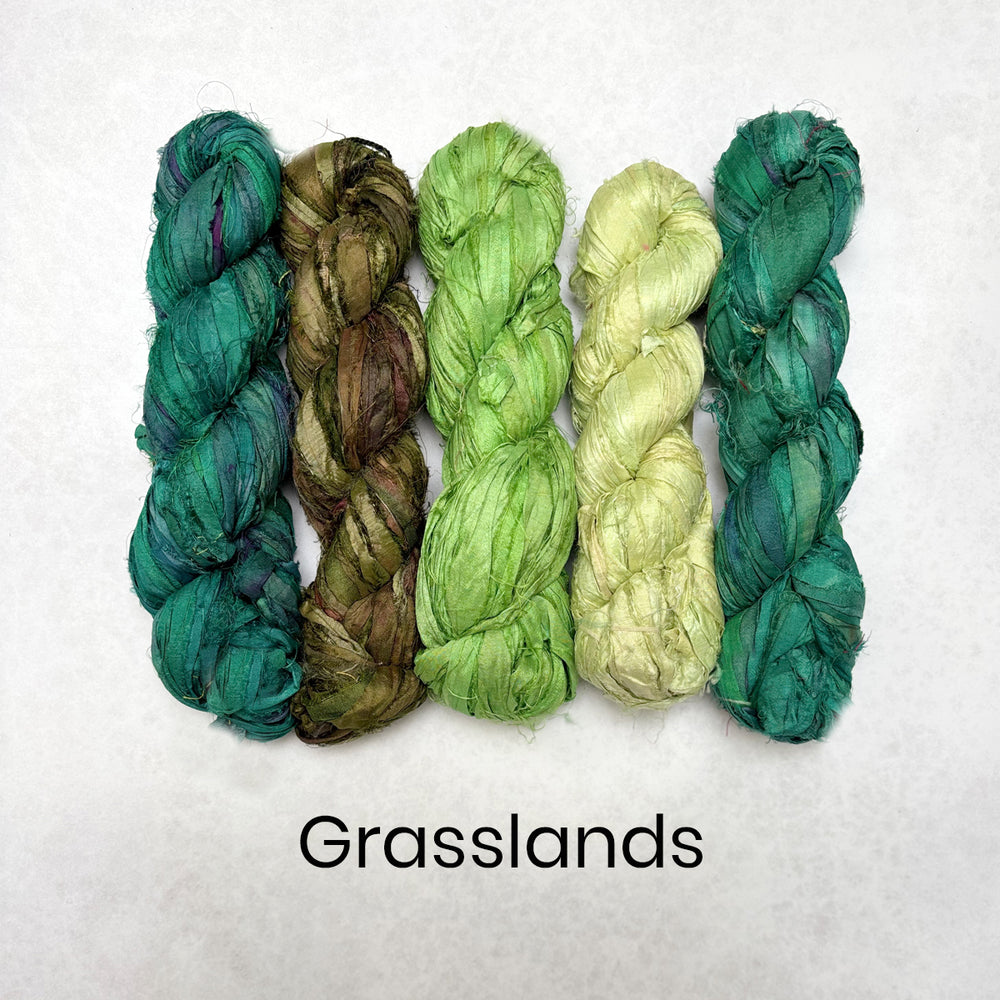 Five skeins of recycled sari silk ribbon in various green shades on a white background with 'Grasslands' text.
