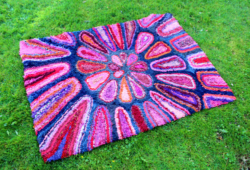 Colourful large rag rug with a vibrant pattern on grass