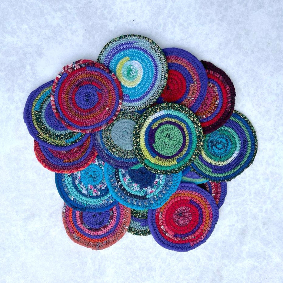 Colorful coiled rope coasters on a white background