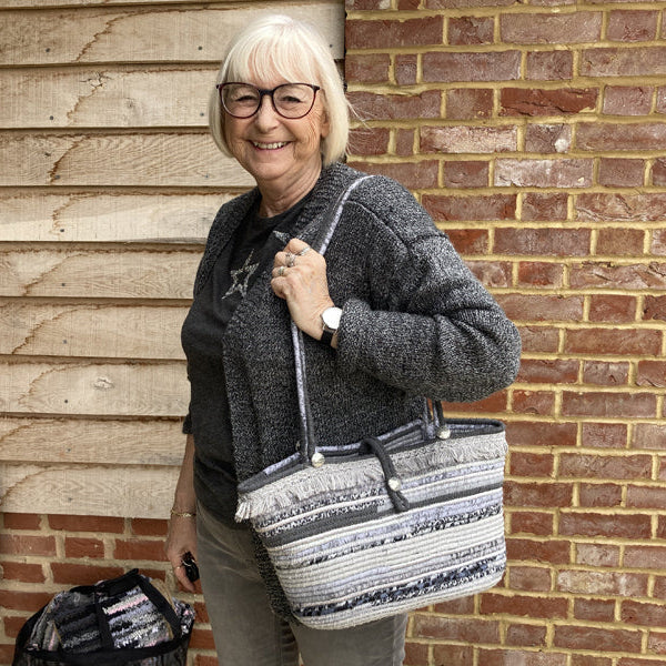 Woman holding a grey coiled rope handmade handbag with handles