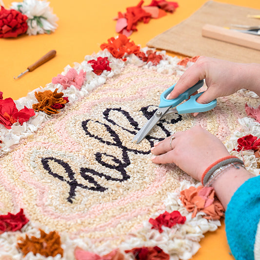 Small handmade rag rug mat with proggy flower border and rug hooked hello centre