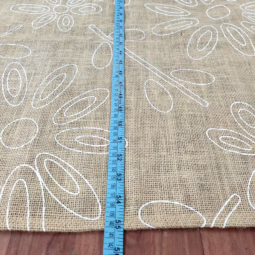 Hessian Fabric with white floral patterns on a brown background, measured with a blue ruler.