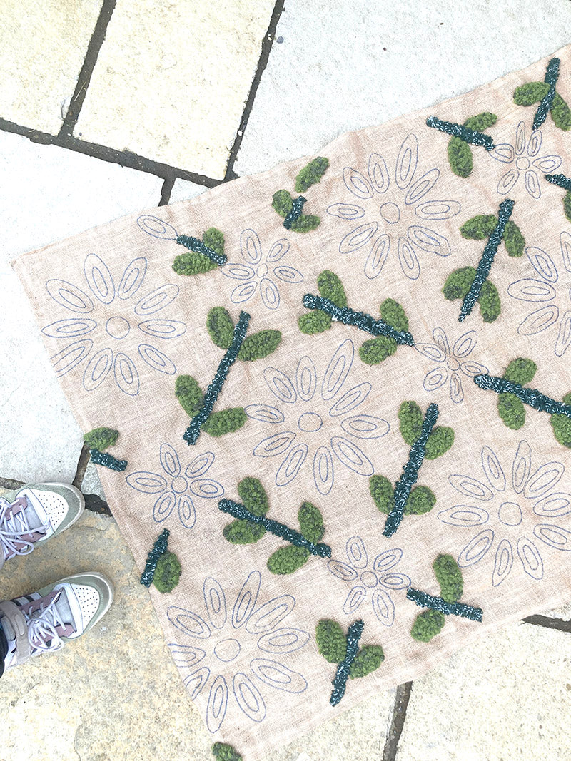 Decorative doormat with floral pattern on a tiled floor