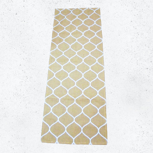 Beige hessian runner with white geometric lantern pattern on a textured white surface