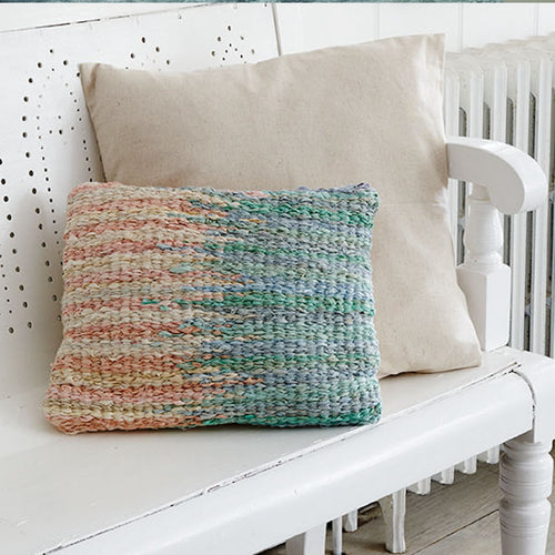 Rectangular peg loom woven cushion with paint drip colour design in blue and pink colours