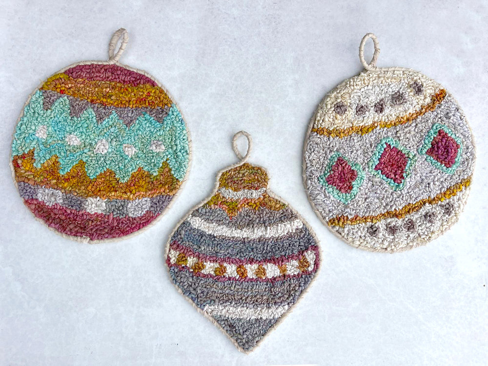 Three rug hooked Christmas ornaments on a white background