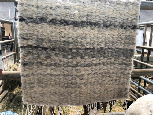 Neutral coloured raw fleece peg loom woven rug in cream and grey from sheeps wool