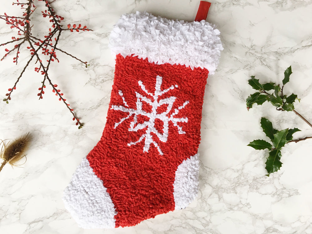 Festive handmade rag rug Christmas hanging stocking decoration in red and white with a snowflake pattern