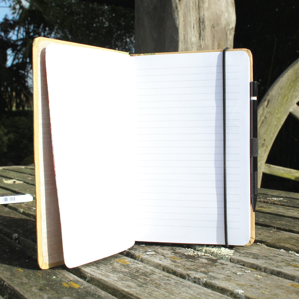 Ragged Life hardback notebook open with a pen and elastic hold 