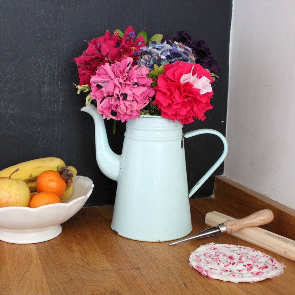 Rag rug flower bouquet in blue red pink and purple. Displayed inside in a vintage white watering can. Made using Ragged Life bouquet kit. 