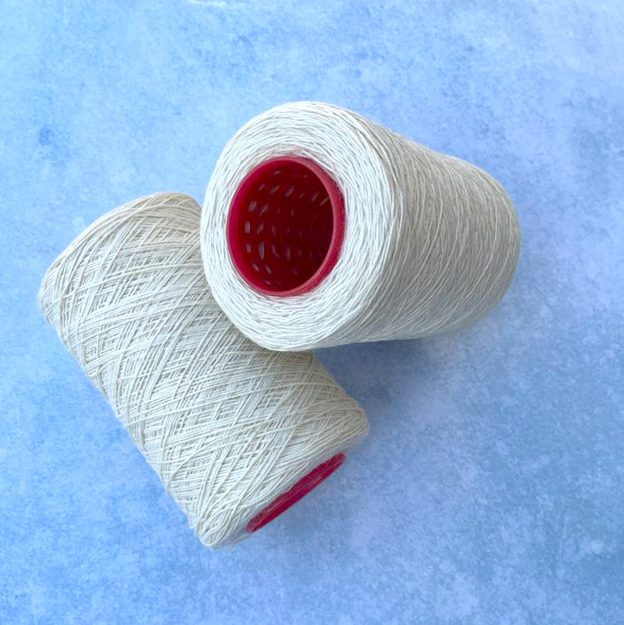 Two cones of 4ply cream warp